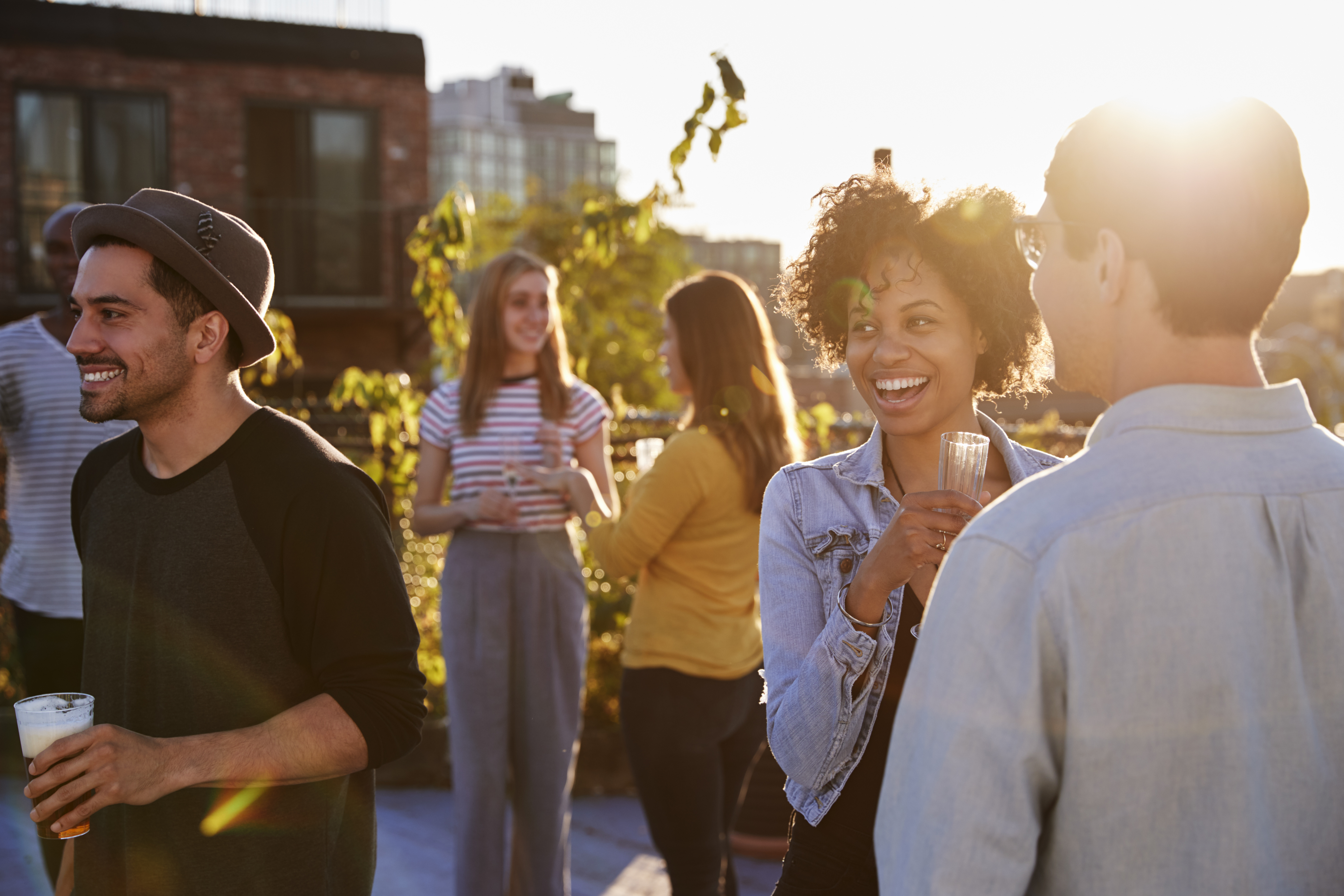 Happy Friends Rooftop Party Backlit By Sunlight